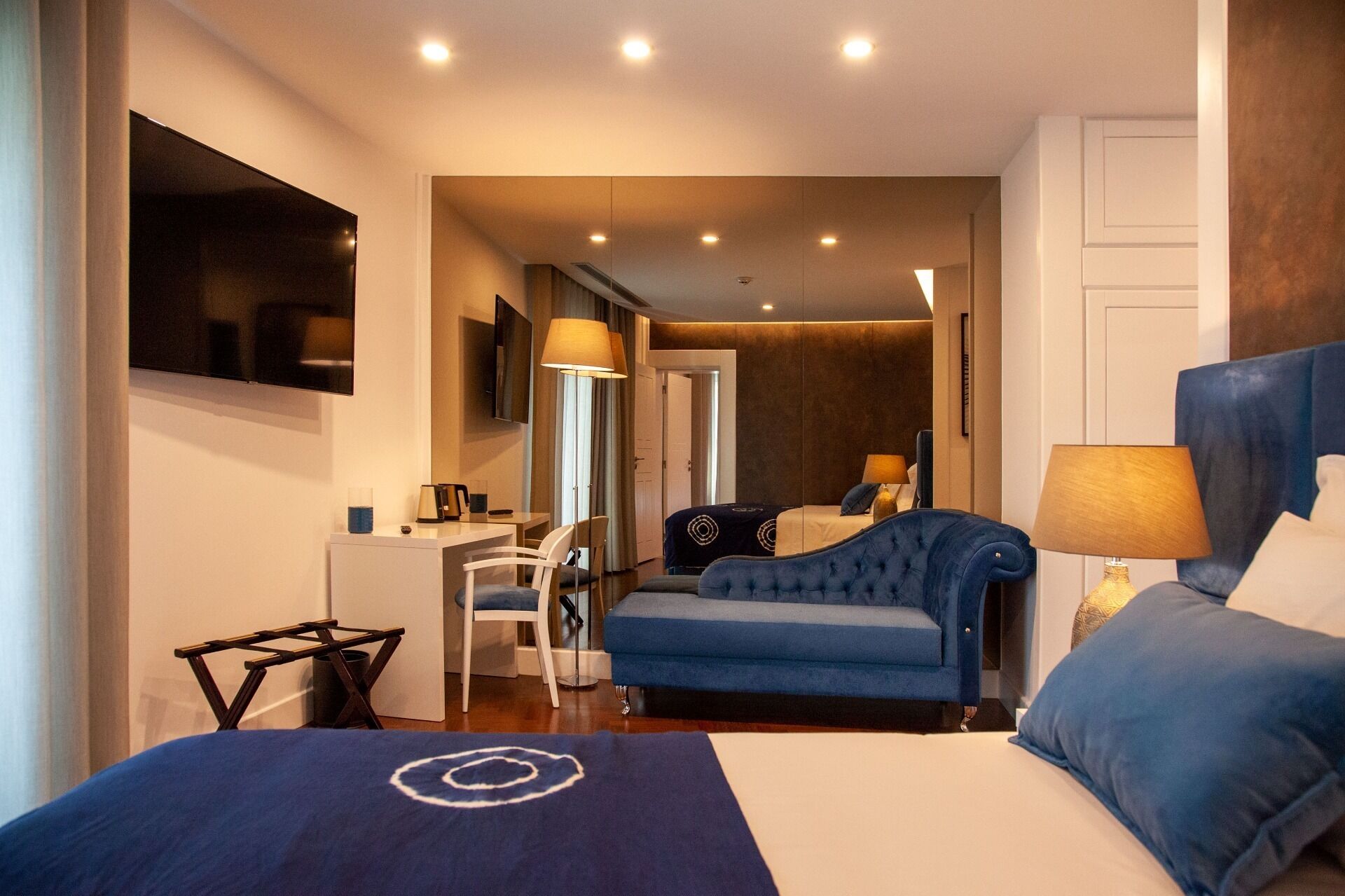 Una habitación de hotel moderna con una cama grande, un escritorio, una silla y un televisor.