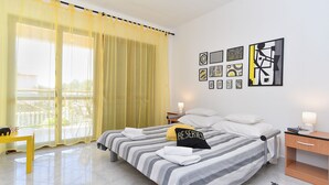 Habitación de hotel con cama, escritorio, silla y obras de arte en la pared.