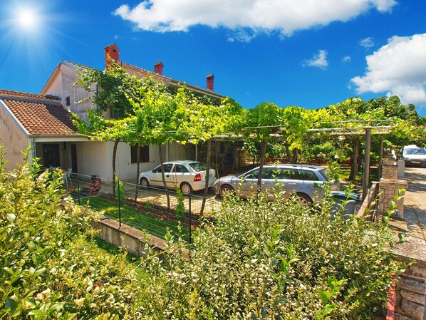Set amidst lush greenery, this house offers a serene retreat with a tiled roof and a visible chimney.