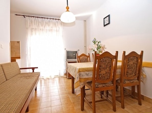 Cozy living space with a sofa, dining table, and television.
