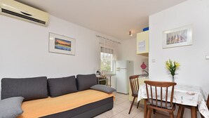 A compact living space with a sofa, a dining table, and a kitchenette.