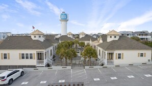 Una hilera de casas de playa con una torre de agua al fondo.