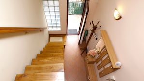 A wooden staircase with a handrail, a view of the outside through a window, and a wall-mounted light fixture. - Apartment 1049/3911 (Istria - Rovinj), 1300m from the beach (Rovinj)