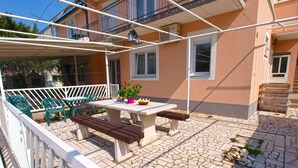 An outdoor patio with a table, benches, and potted plants. - Apartment 1052/3918 (Istria - Fažana), 300m from the beach (Fažana)