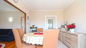 A dining area with a table, chairs, and a wooden cabinet. - Apartment 1056/4401 (Istria - Pula), 500m from the beach (Pula)