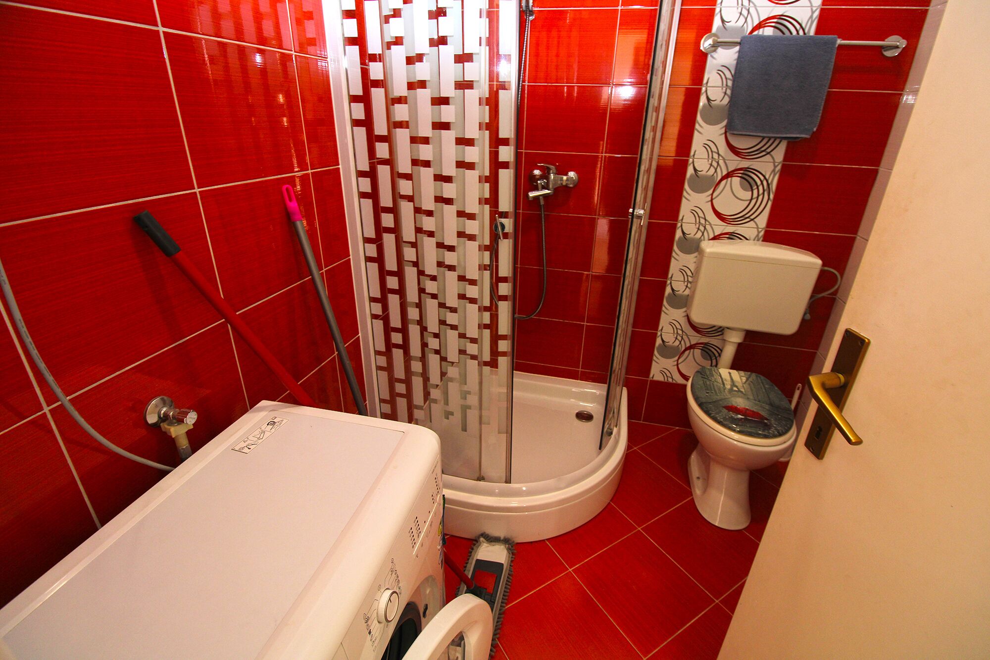 Une salle de bain avec douche, toilettes et lavabo.