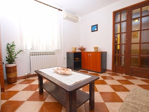 Cozy room with a checkered floor, featuring a wooden table, bench, and potted plant.