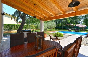 Enjoy al fresco dining and relaxation by the pool.