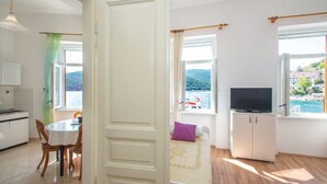 A bright room with a bed, a TV, and a view of the sea. - Apartment 1093/9443 (Istria - Rabac), 100m from the beach (Rabac)