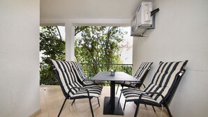 A balcony with a table and four chairs, featuring striped cushions and a black metal frame. - Apartment 1099/9469 (Istria - Rovinj), 400m from the beach (Rovinj)
