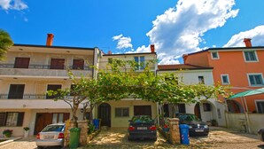 A residential street with parked cars, a tree-lined pathway, and buildings with balconies and windows. - Apartment 1099/9469 (Istria - Rovinj), 400m from the beach (Rovinj)