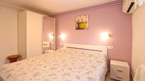 A bedroom with a bed, bedside tables, a mirror, and a wall-mounted light fixture. - Apartment 1112/9595 (Istria - Fažana), 350m from the beach (Fažana)