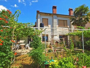 A two-story stone house with a garden in front, a wooden deck, and a brick chimney. - Apartment 1142/9868 (Istria - Valbandon), 750m from the beach (Valbandon)