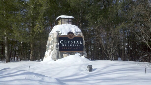 A snow-covered sign for Crystal Mountain Resort & Spa, surrounded by trees. - Crystal Mtn Condo, walk to lift,  soaking tub, short drive to Iron Fish & Lk MI (Thompsonville)