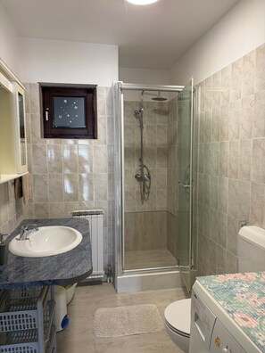 A bathroom with a glass-enclosed shower, a sink with a marble countertop, a toilet, and a washing machine. - Apartment 1183/10822 (Istria - Banjole), 1000m from the beach (Banjole)