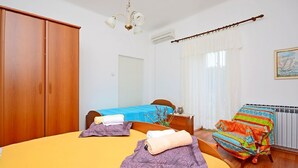 A room with two beds, a wooden wardrobe, a chair, and a radiator. - Apartment 1189/10858 (Istria - Premantura), 500m from the beach (Premantura)