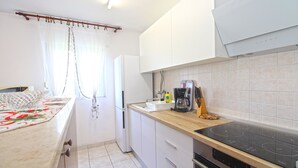 A compact kitchen with a countertop, sink, and a built-in oven.