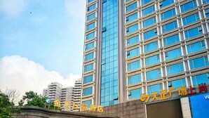 A hotel with a modern facade, featuring a prominent sign in a foreign language. - Jin Long Wan Hao Hotel (Wuzhou)