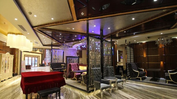 A luxurious lobby with a red table, plush seating, and a marble floor. - Jin Long Wan Hao Hotel (Wuzhou)