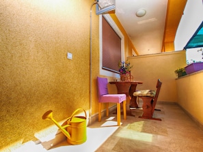 Enjoy a tranquil retreat on your balcony with a table, chairs, and a vase of flowers.