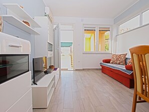 Relax in this stylish living space with an entertainment unit, comfortable sofa, and a view of the outdoors.