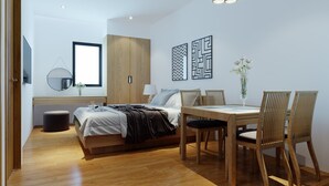 Un dormitorio moderno con cama, mesita de noche y un comedor con mesa y sillas.