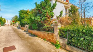A residential street with houses, a brick wall, and greenery. - House 1214/11158 (Istria - Banjole), 400m from the beach (Banjole)