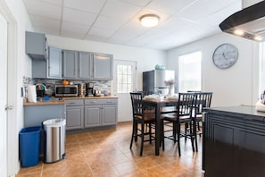 Enjoy cooking in this fully equipped kitchen with a dining table and microwave, stove, and other appliances.