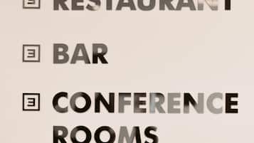 Un letrero que indica las instalaciones disponibles: restaurante, bar y salas de conferencias.