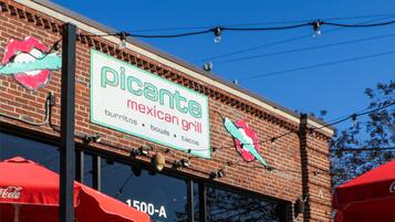 A brick building with a sign for 'Picante Mexican Grill' and a Coca-Cola sign.