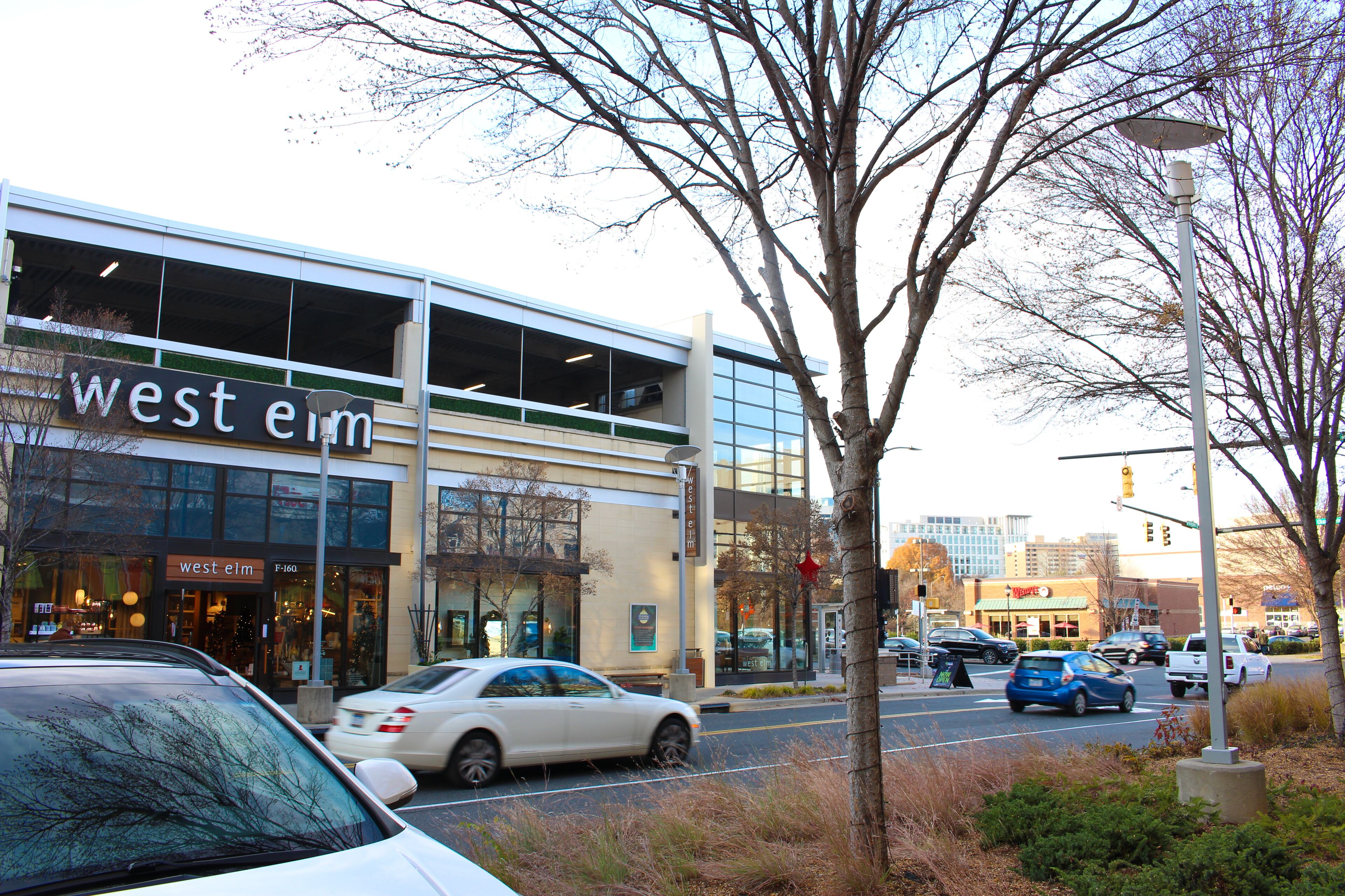 A modern building with a large glass facade and signage reading 'west elm.'