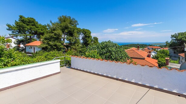 Eine Dachterrasse mit freiem Blick auf das Meer und die umliegenden Häuser.
