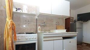 A compact kitchen with a stove, oven, sink, and cabinets. - Apartment 1220/17851 (Istria - Premantura), 500m from the beach (Premantura)