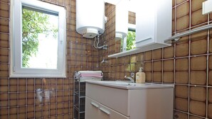 A bathroom with a window, a sink, a mirror, and a towel rack. - Apartment 1220/17851 (Istria - Premantura), 500m from the beach (Premantura)
