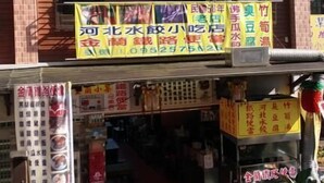 A two-story building with multiple signs advertising various businesses. - Jin Lan Homestay (Zhuqi)