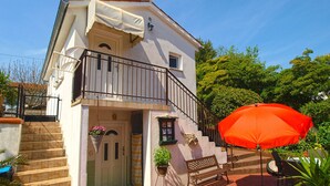A two-story house with a balcony, a red umbrella, and a bench. - Apartment 1227/11310 (Istria - Premantura), 300m from the beach (Premantura)