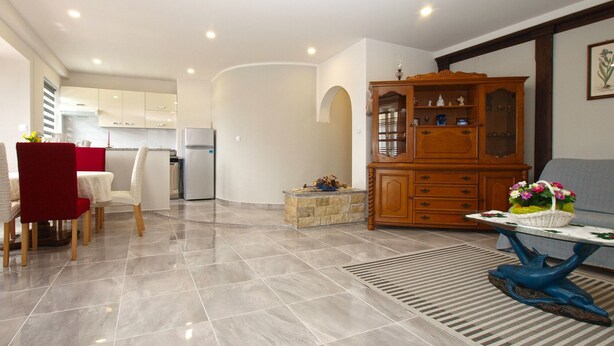 A spacious living area with a dining table, chairs, a wooden cabinet, and a sofa. - Apartment 1251/11917 (Istria - Fažana), 350m from the beach (Fažana)