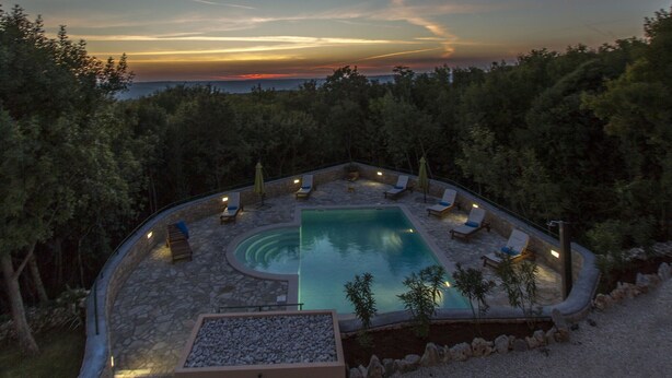 A pool area with lounge chairs and a view of the sunset over the water. - Apartment 1255/12014 (Istria - Koromačno), 4000m from the beach (Koromačno)