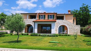 A two-story house with a stone facade, a tiled roof, and a well-maintained lawn. - Apartment 1255/12014 (Istria - Koromačno), 4000m from the beach (Koromačno)