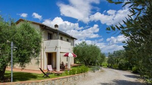 A two-story house with a stone wall and a gravel driveway. - Borgo Fontana by Interhome (Vinci)