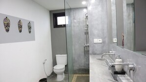 Een moderne badkamer met een douchecabine van glas, een toilet en een wastafel met spiegel.