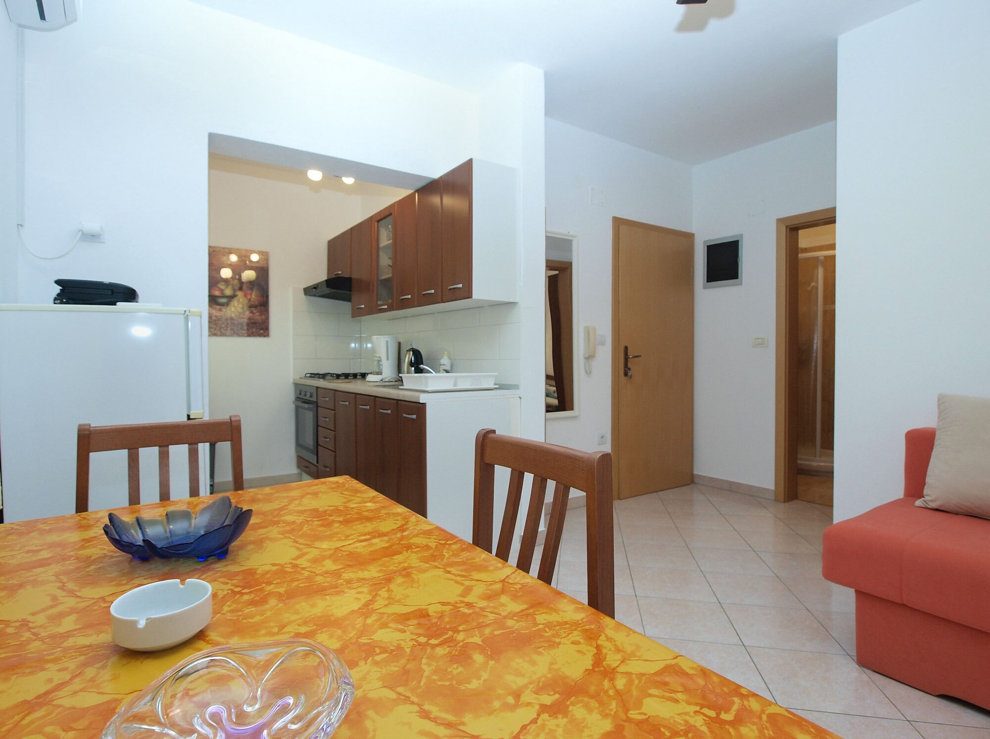 A compact living space with a dining area, kitchenette, and a small seating area.