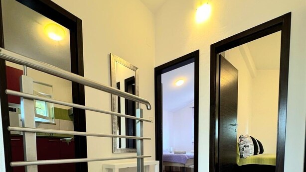 Una escalera con barandas metálicas que conduce a una habitación con una cama y un edredón verde.