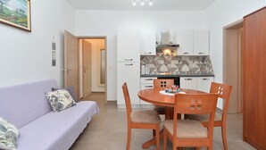 A compact living space with a dining area, kitchenette, and a sofa. - Apartment 1293/12300 (Istria - Fažana), 200m from the beach (Fažana)