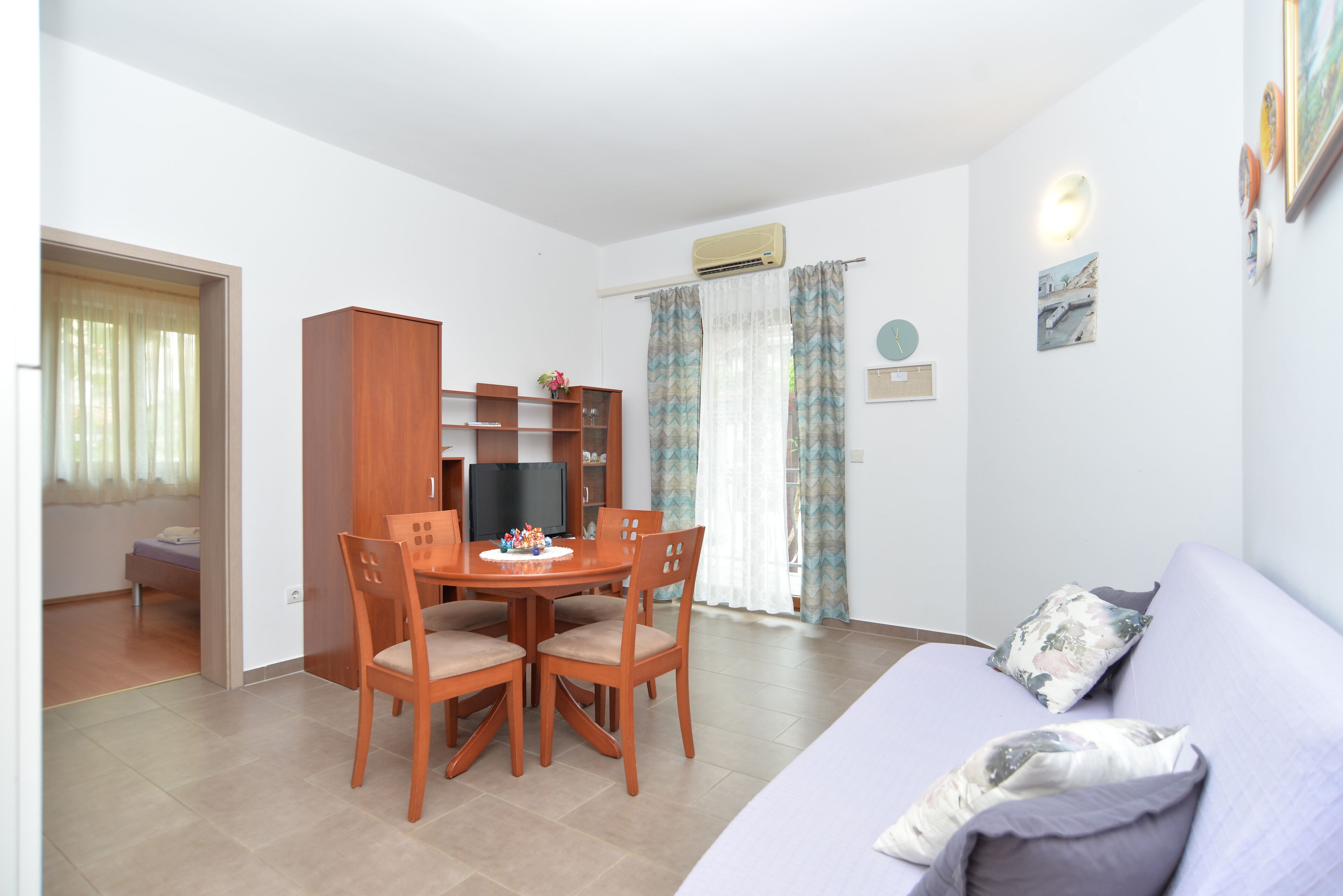 A compact living space with a dining area, a sofa, and a TV.