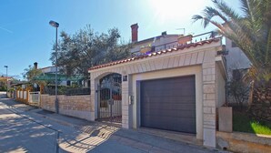 Propiedad residencial con entrada porticada, garaje y vista a la calle.