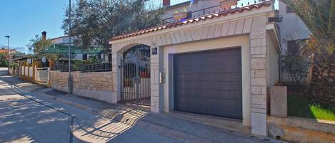 A residential property with a gated entrance, a garage, and a street view.