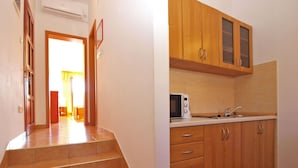 Una cocina con gabinetes de madera, un microondas y un lavamanos.
