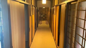 Un couloir doté d’un sol recouvert de moquette, de murs en bois et d’un panneau de signalisation verte indiquant la sortie.