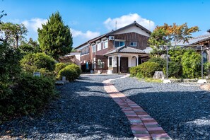 A residential building with a gravel driveway and a brick pathway leading to the entrance. - Shiga Biwa Lake Shanshui House (Takashima)